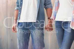 Composite image of hip young couple holding hands