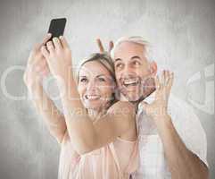 Composite image of happy couple posing for a selfie