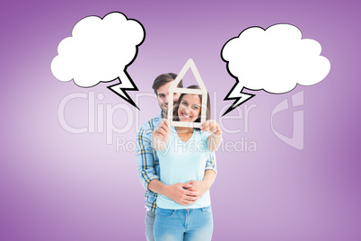 Composite image of happy young couple with house shape