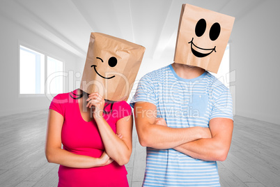 Composite image of young couple with bags over heads