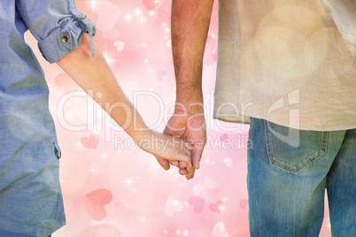 Composite image of couple holding hands in park