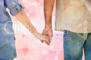Composite image of couple holding hands in park