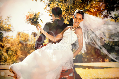 Newlywed couple sitting on scooter in park