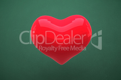 Red heart shaped balloon against green