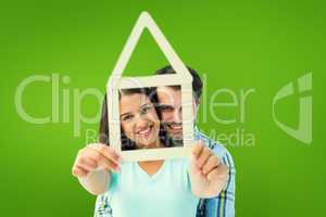 Composite image of happy young couple with house shape