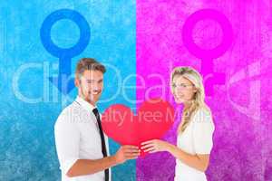 Composite image of attractive young couple holding red heart