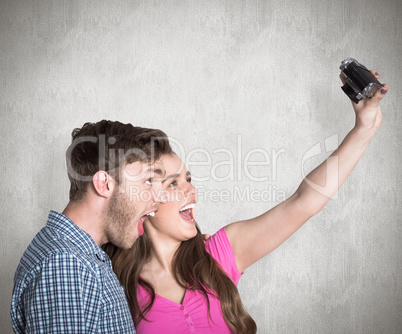 Composite image of couple taking selfie with digital camera Composite image of couple taking selfie with digital camera