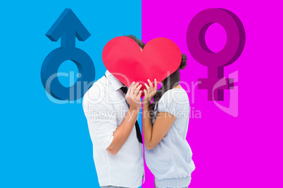 Composite image of couple covering their kiss with a heart