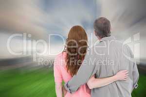 Composite image of casual couple standing arm around