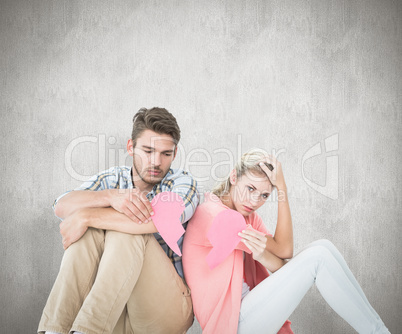 Composite image of attractive young couple sitting holding two h