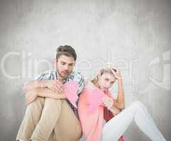 Composite image of attractive young couple sitting holding two h