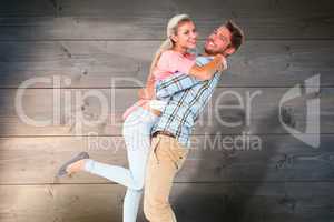 Composite image of handsome man picking up and hugging his girlf
