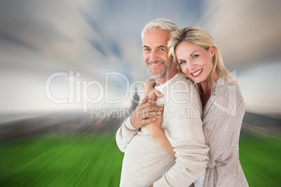 Composite image of happy couple standing and hugging