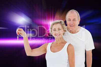 Composite image of mature couple smiling at camera with new hous