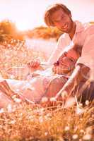 Attractive couple relaxing in the countryside smiling at camera