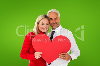 Composite image of handsome man getting a heart card form wife