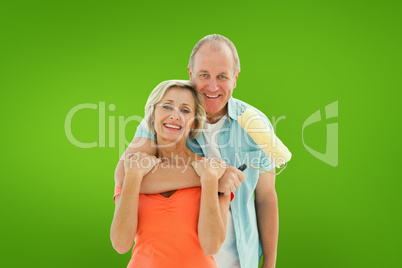 Composite image of happy older couple holding paint roller