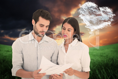 Composite image of attractive young couple reading their bills