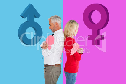 Composite image of couple holding two halves of broken heart