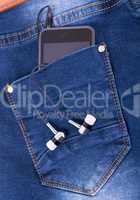 MP3 player and earphones sticking out of jeans pocket