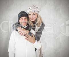 Composite image of happy couple in winter fashion embracing