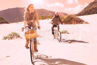 Carefree couple going on a bike ride on the beach