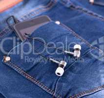 MP3 player and earphones sticking out of jeans pocket