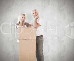 Composite image of happy couple leaning on pile of moving boxes