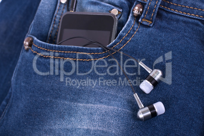 MP3 player and earphones sticking out of jeans pocket