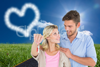 Composite image of attractive young couple showing new house key