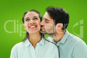Composite image of handsome man kissing girlfriend on cheek