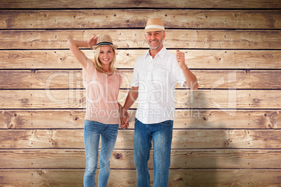 Composite image of happy couple walking holding hands