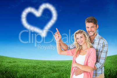 Composite image of attractive young couple embracing and pointin