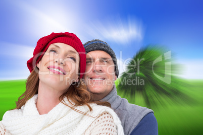 Composite image of happy couple in warm clothing