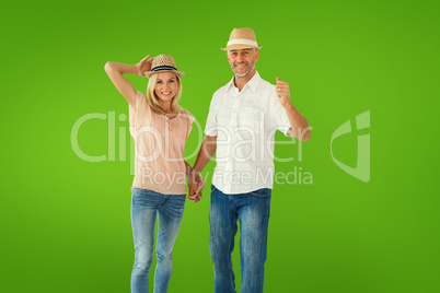 Composite image of happy couple walking holding hands Composite image of happy couple walking holding hands