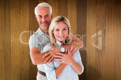 Composite image of happy couple smiling at camera and embracing