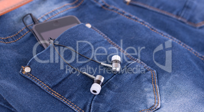 MP3 player and earphones sticking out of jeans pocket