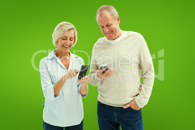 Composite image of happy mature couple using their smartphones