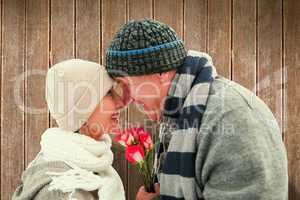 Composite image of happy mature couple in winter clothes with ro