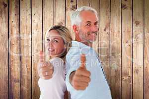 Composite image of smiling couple showing thumbs up together