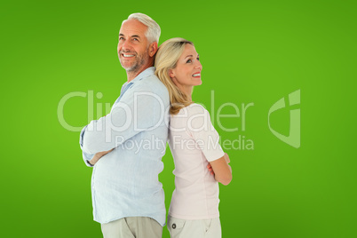 Composite image of smiling couple standing leaning backs togethe