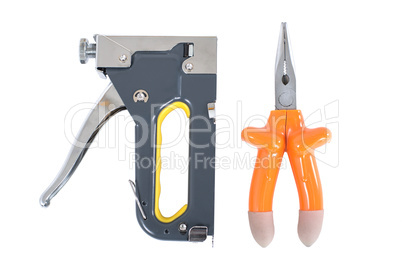 pliers and staple gun in hand on a white background