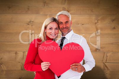 Composite image of handsome man getting a heart card form wife