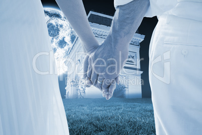 Composite image of bride and groom holding hands close up