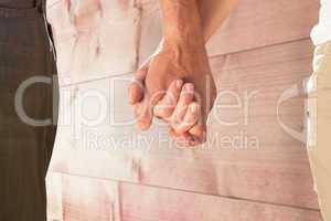 Composite image of happy senior couple holding hands