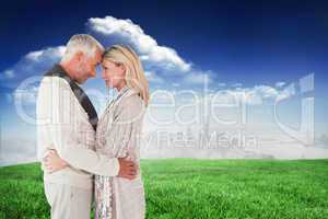 Composite image of happy couple standing and hugging
