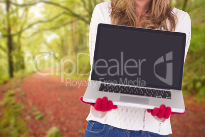 Composite image of festive blonde showing a laptop