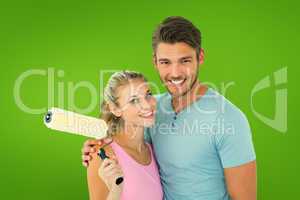 Composite image of young couple hugging and holding paint roller