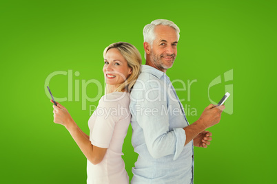 Composite image of happy couple texting on their smartphones Composite image of happy couple texting on their smartphones