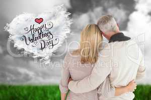 Composite image of happy couple standing with arms around